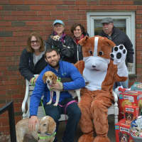 <p>Paws and Play Resort and Training Center owner Matt Sellechia with his mascot, delivering donated toys to the animals in ned at Pet Rescue in Harrison.</p>