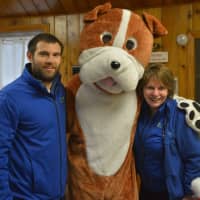 <p>Paws and Play Resort and Training Center owner Matt Sellechia with his mascot, delivering donated toys to the animals in ned at Pet Rescue in Harrison.</p>