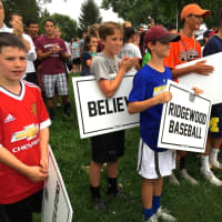 <p>Community members waiting for The U14 Ridgewood Junior League All Star Team to emerge from theirs buses after arriving at Van Neste Memorial Square Park. </p>