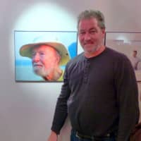 <p>Photographer David Rocco with his photo of Pete Seeger.</p>