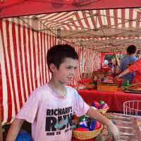 <p>Eight-year-old Hudson Feeney runs the Sports Wheel booth.</p>