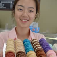 <p>Ann Choi of Allendale&#x27;s new Cafe Moncher holds some freshly baked macarons.</p>