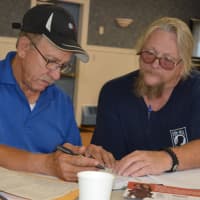 <p>John Opatovsky, right, helps a veteran fill out disability paperwork for the VA at the Bergenfield headquarters of Disabled American Veterans, Northern Valley Chapter 32.</p>
