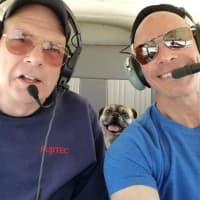 <p>Paramus Police Det. Sgt. Glenn Pagano and copilot/rescue official Andy Davie fly Rocco from Ohio to New York to meet his new family.</p>