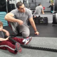 <p>Moshe Klyman of Underground Training in Tenafly trains a young client on battle ropes.</p>
