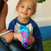 <p>Olivia Burks&#x27; little one has fun with painted toes.</p>
