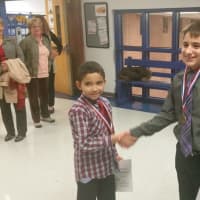 <p>Jonell Rios Losado, left, shakes hands with Dean Fejes after the two were honored at the Putnam Valley Board of Education&#x27;s November meeting.</p>