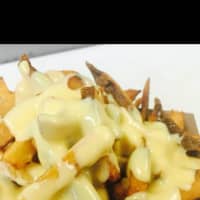 <p>Cheese sauce on top of fresh-cut fries at Melts in Armonk.</p>