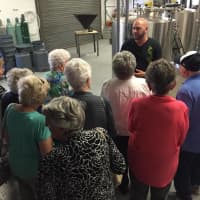 <p>Brix City&#x27;s owners shared their traditional Belgian style beers with World War II veteranss and Holocaust survivors. Here co-owner Joe Delcalzo gives a tour of the brew house.</p>