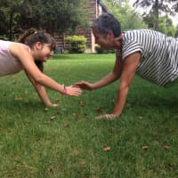 <p>Charlie Simpson, 12, practices core-building exercises with mom and Heart and Sole coach Merrill Simpson in their front yard.</p>
