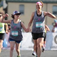 <p>Chrissy Vita of Mahwah, left, crosses the Iron Girl Sandy Hook finish line with Bergen County Girls on the Run Coordinator Terri Peri.</p>