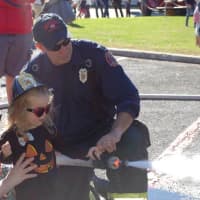 <p>Chrissy LaBate and her daughter Veronica learn how to spray a fire hose at the Ho-Ho-Kus Fire Department open house.</p>