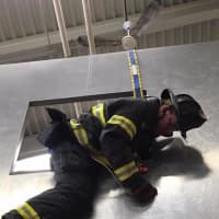 <p>A firefighter exits a simulated window during the training session. </p>