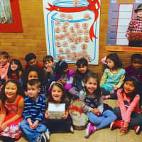<p>Students at Barnard Early Childhood Center assemble by a poster with paper pennies on it that represent their donations to the leukemia charity.</p>
