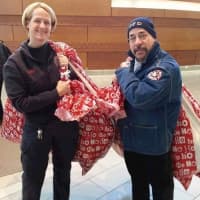 <p>Beth Fournier and Paterson Fire Association Vice President Louis Vega deliver stuffed animals to patients in the hospital on Christmas Eve.</p>