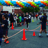 <p>A woman crosses the finish line at the 8th annual Run The Palisades 5K/10K.</p>