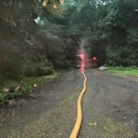 <p>The hose stretching from the hydrant to the house.</p>