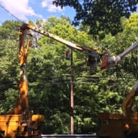 <p>Eversource crews work to reroute power on Newtown Turnpike in Weston after a tree fell on the wires.</p>
