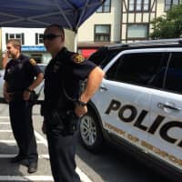 <p>Officers meet with visitors during on a sidewalk sales day in Katonah.</p>