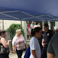 <p>Locals stop by a Bedford Police Department table on a sidewalk sales day in Katonah.</p>