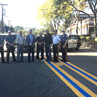 <p>Midland Park police and officials proudly unveil their blue line on Godwin Avenue outside police HQ.</p>