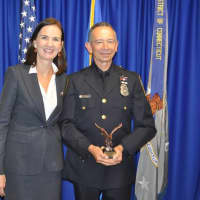 <p>U.S. Attorney Deirdre Daly with Officer Cesar Ramirez after Ramirez was recognized for organizing an Aug. 3 vigil outside the Norwalk Police Department headquarters.</p>