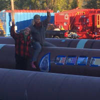 <p>Two protestors sit atop one of the pipes Monday being used to construct the Algonquin Pipeline project.</p>