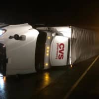<p>A CVS truck lies on its side on the shoulder of I-84 in Danbury after an early morning crash Wednesday.</p>