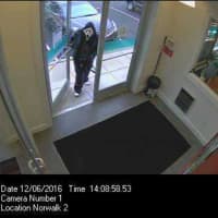 <p>The suspect enters the First County Bank in Norwalk wearing a ghost mask, a black leather jacket, and a black-hooded sweatshirt.</p>