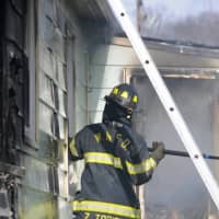 <p>A Central Nyack firefighters works to knock down a fire at a Waldron Avenue home that was filled with garbage.</p>