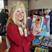 <p>Cupcake Cutie Sonja Kramer Karlis of Cresskill holds up a toy she helps sort at the toy drive.</p>