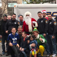 <p>Youngsters join Santa, Elf and the men behind the badges at a hospital stop.</p>