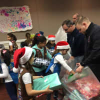 <p>The scouts fill garbage bags with presents for Lil Ryu, which firefighters delivered to him in Little Ferry Thursday evening.</p>