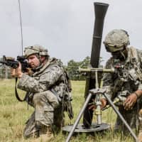 <p>Spc. Hakeem English, a soldier assigned to Headquarters Co., 2nd Battalion, 108th Infantry, sets up a 60mm mortar while Spc. Elliot Beaumont provides security at Fort Polk, La.,</p>