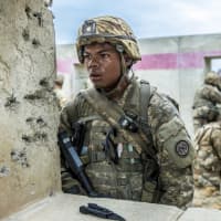 <p>Army National Guard Sgt. Geovany Martinez, with Co. C, 1st Battalion, 69th Infantry, watches his field of fire after securing a building during a live-fire exercise at Ft. Polk, La.,</p>