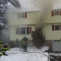 <p>Norwalk firefighters tackle the blaze in the home on Kettle Road on Monday.</p>