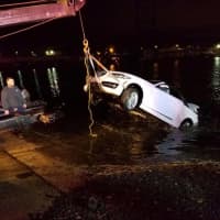<p>The car is pulled from the Saugatuck River early Sunday in Westport. An elderly man died after the car went into the chilly waters Saturday evening, but first responders saved a woman.</p>