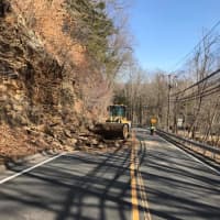 <p>A crew from the Redding Highway Department clears debris after a rockslide on Route 107 on Tuesday morning.</p>