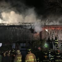 <p>Firefighters from several towns battle a blaze in a barn Sunday night in Georgetown.</p>