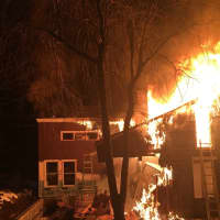 <p>A fire tears through a home at 8 White Birch Road in Weston late Friday.</p>