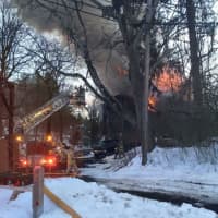 <p>A hose is stretched at the scene of the barn fire on Church Street.</p>