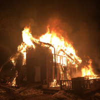 <p>The house at 8 White Birch Road in Weston is filled with flames late Friday.</p>