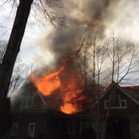 <p>A large blaze burns through  the roof of the home at 45 Londonderry Drive in Greenwich on Saturday afternoon.</p>
