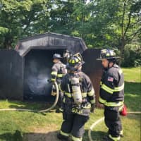 <p>Crews work to extinguish a small shed fire.</p>