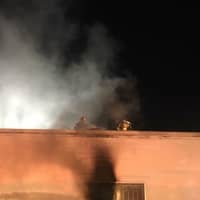 <p>Crews from Bethel and Stony Hill fire departments cut a hole in the roof of a burning commercial building on Diamond Street to alleviate smoke conditions.</p>