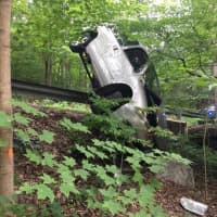 <p>A van is balanced after it went into and over the guardrail at the intersection of Hammertown Road and Wildhorse Court in Monroe on Thursday evening.</p>