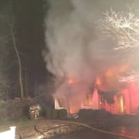 <p>Firefighters respond to the fire at a home on Shadow Lane in Wilton Thursday night.</p>