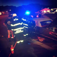 <p>A crew from the Monroe Volunteer Fire Department checks the classic car for fire.</p>