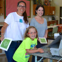 <p>DAC Visual Arts Director Beth Cherico and instructor Jill Sarver help Anora Voss with a printmaking project.</p>