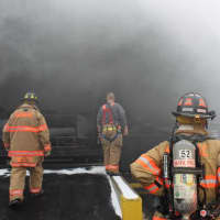 <p>Mahopac firefighters keep an eye on the entry crews working the fire.</p>
